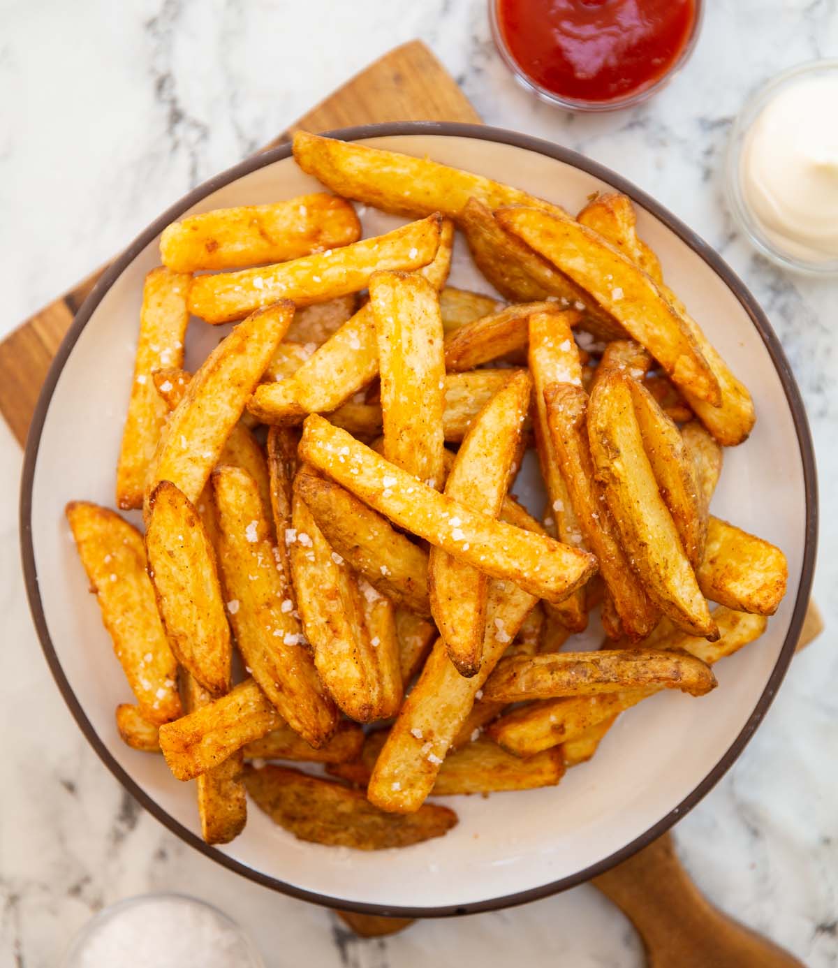 air fryer chips on small white place on wooden chopping board