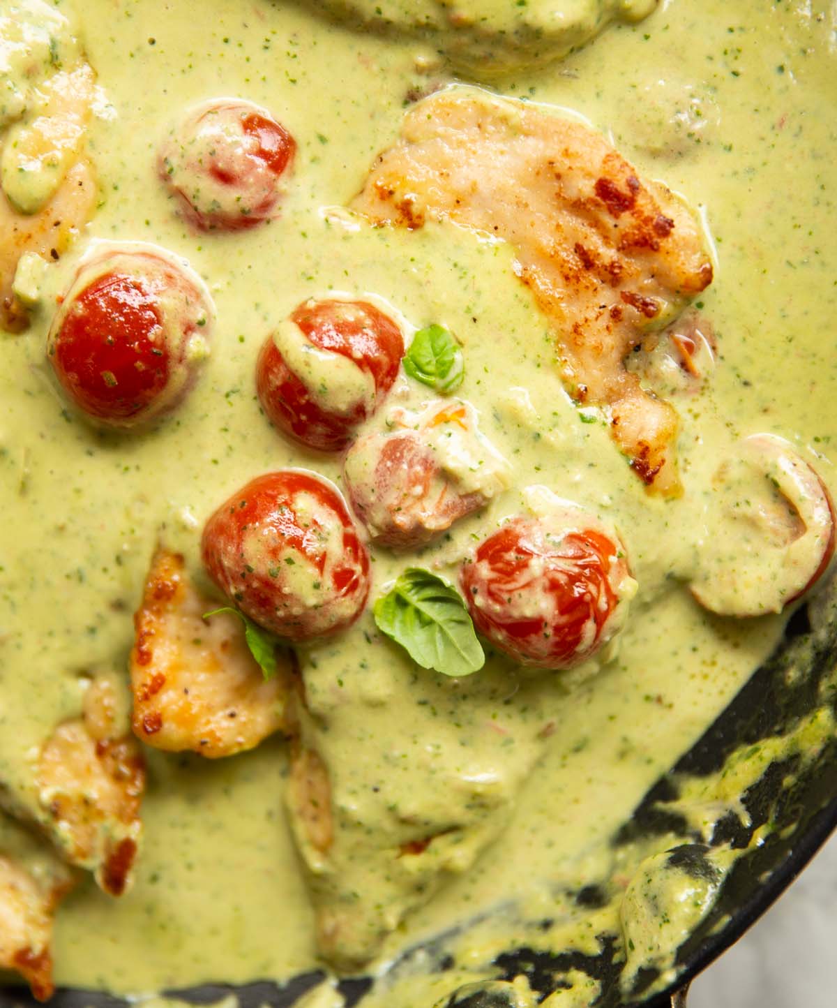 overhead shot of creamy pesto chicken in pan