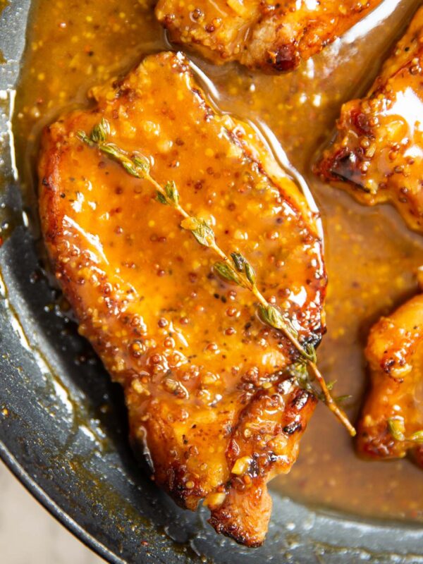 honey mustard pork chop in pan garnished with fresh thyme