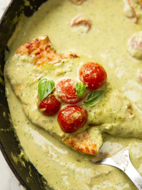 pesto cream chicken in pan with spatula digging in