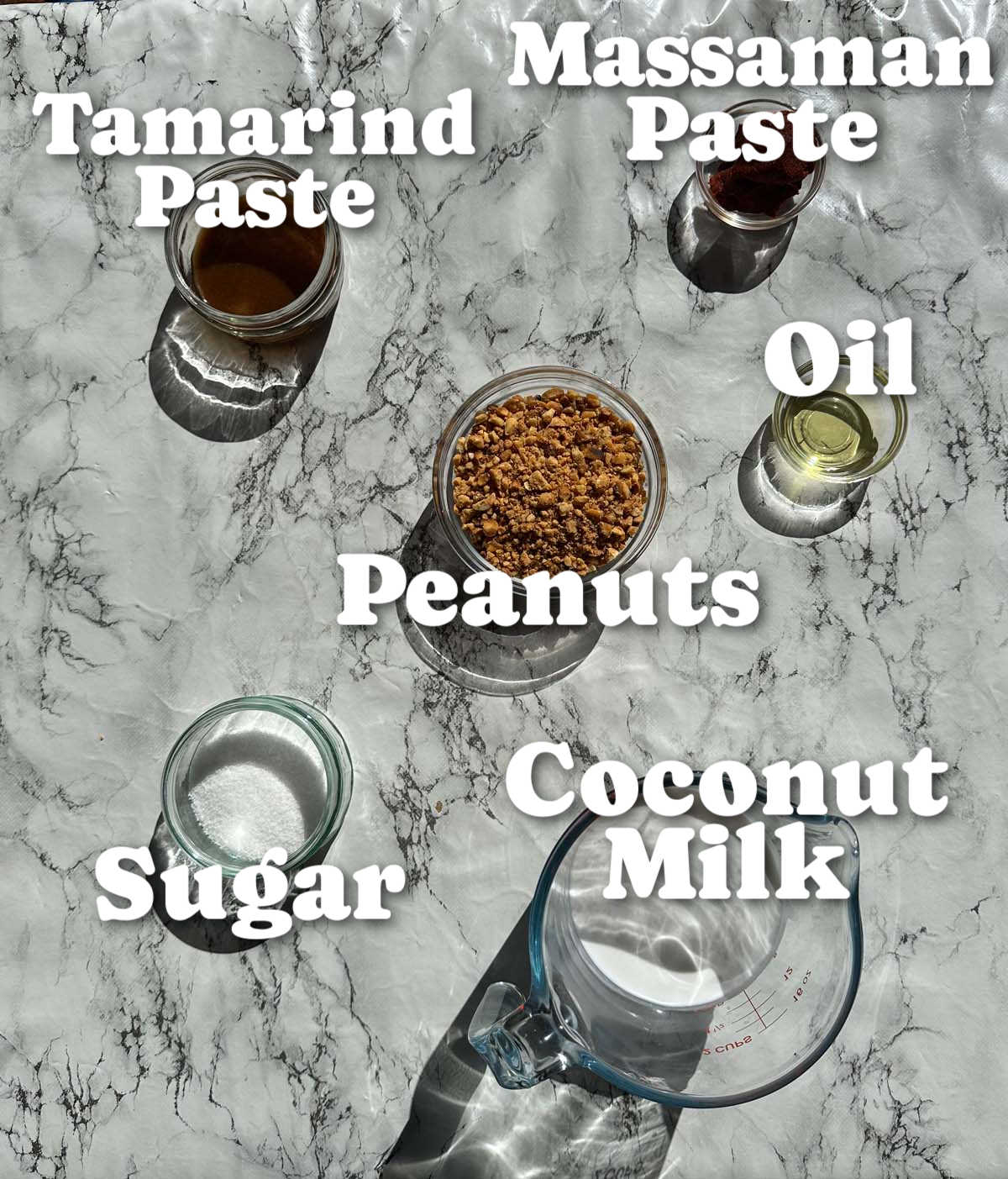 overhead shot of thai satay sauce ingredients with text labels