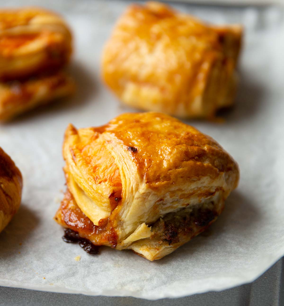 close up shot of sausage cheese onion puff on baking tray