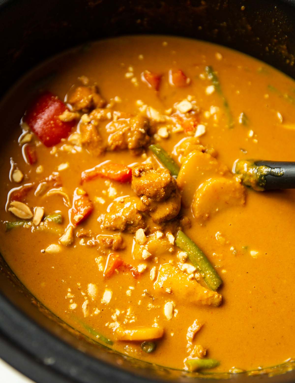 close up shot of slow cooked satay chicken in the slow cooker
