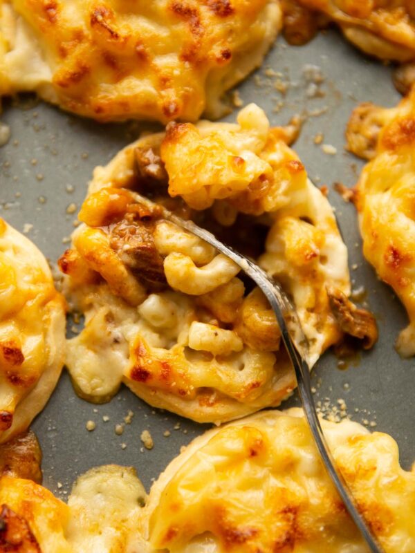 close up of silver fork digging into mac and cheese steak pie