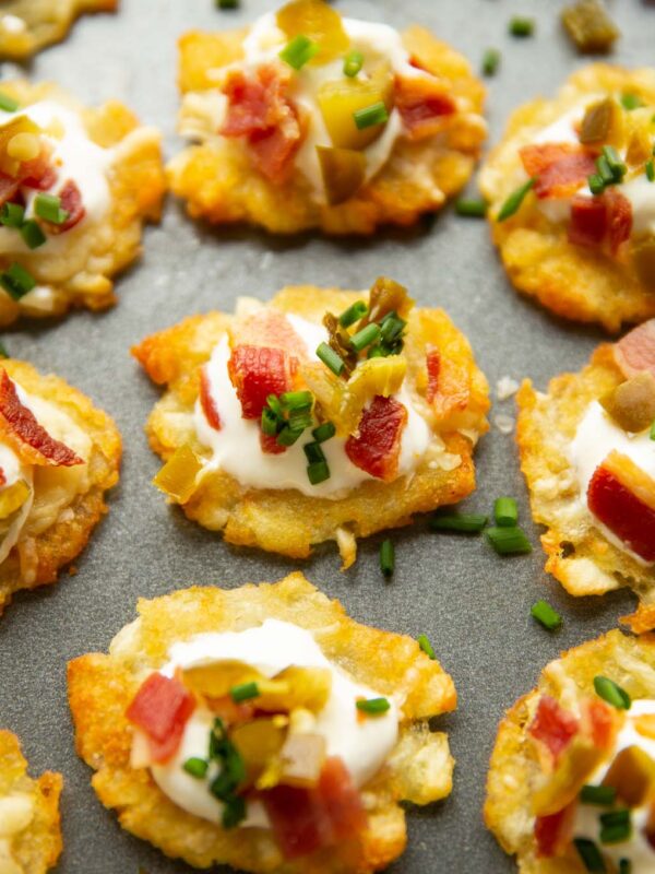 close up shot of smashed tater tots on large grey tray