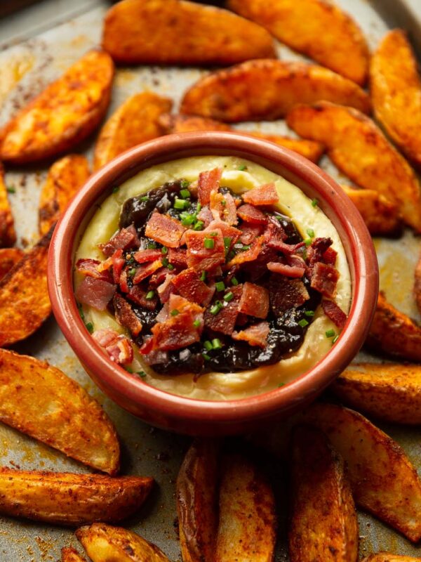 baked brie with bacon and caramelised onion on baking tray with potato wedges