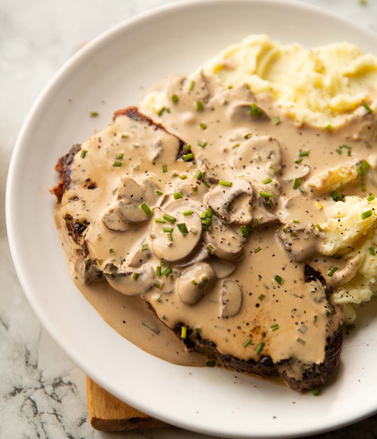 steak and mashed potatoes on small white plate