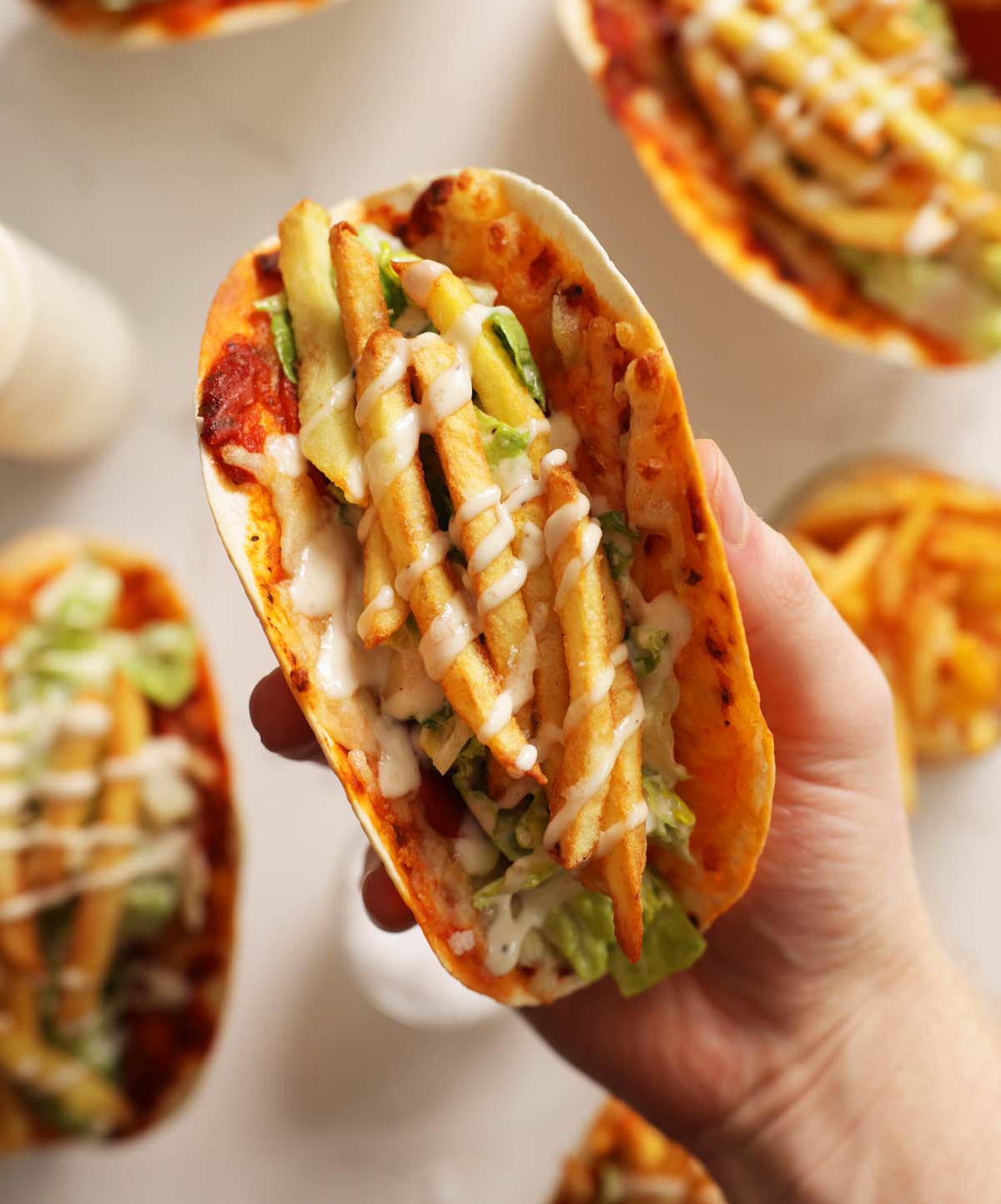 close up overhead shot of hand holding caesaroni taco