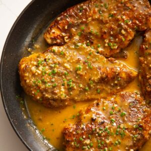 cajun chicken breasts in pan coated in butter sauce