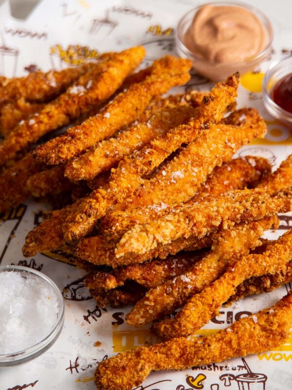 chicken fries stacked on each other with sauces in the background