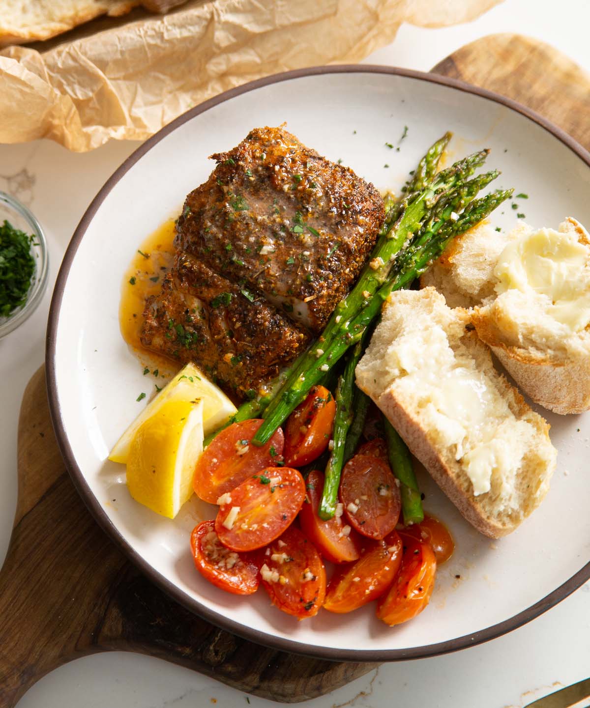 overhead shot of baked cajun cod on small white plate