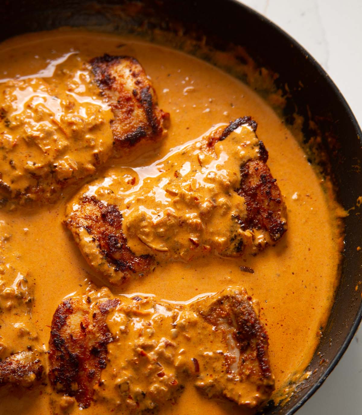 chicken thighs in a pan coated in a creamy paprika sauce