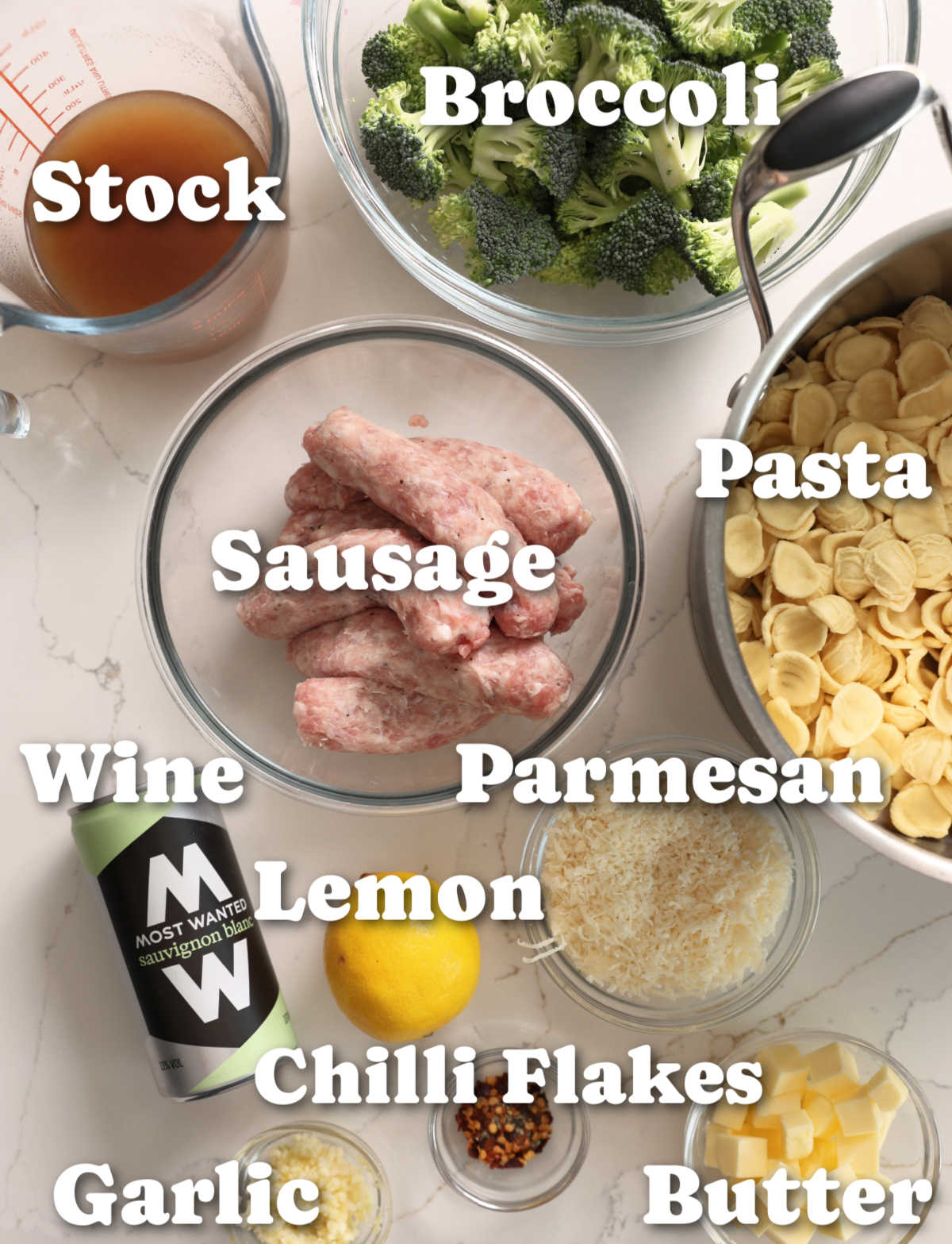 overhead shot of sausage and broccoli pasta ingredients with text labels
