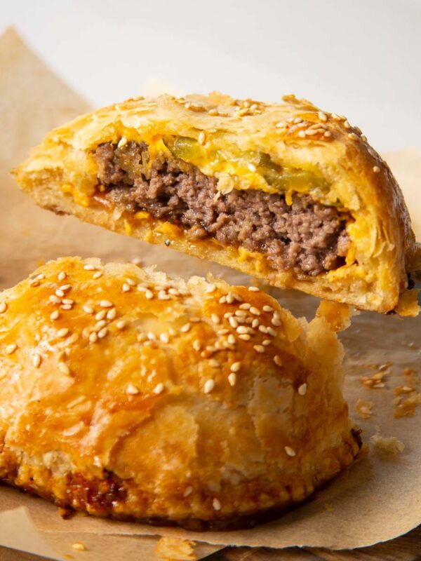 close up shot of knife holding half of cheeseburger wellington showing filling
