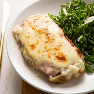 chicken croque monsieur on small white plate with salad