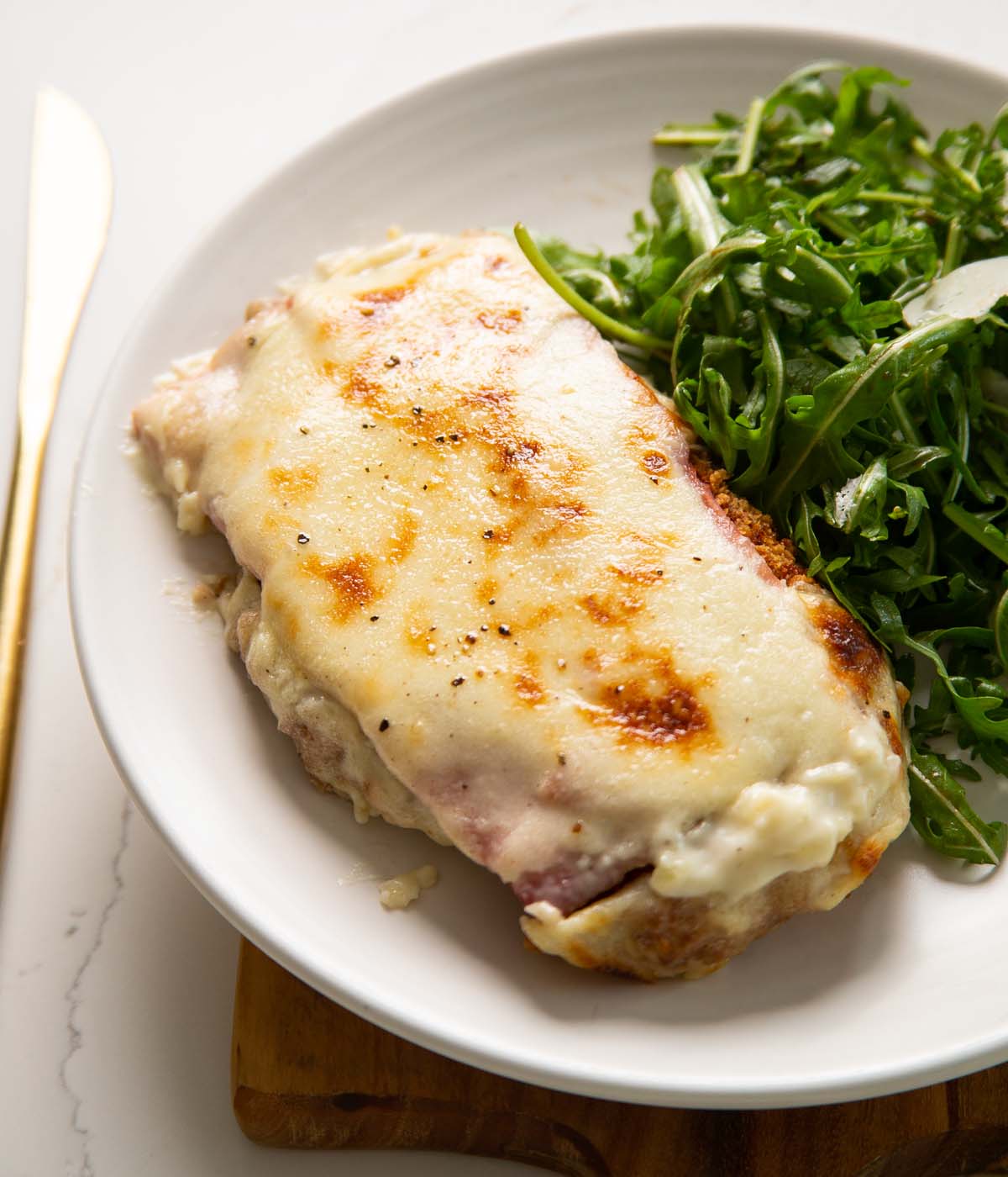 chicken croque monsieur on small white plate with salad