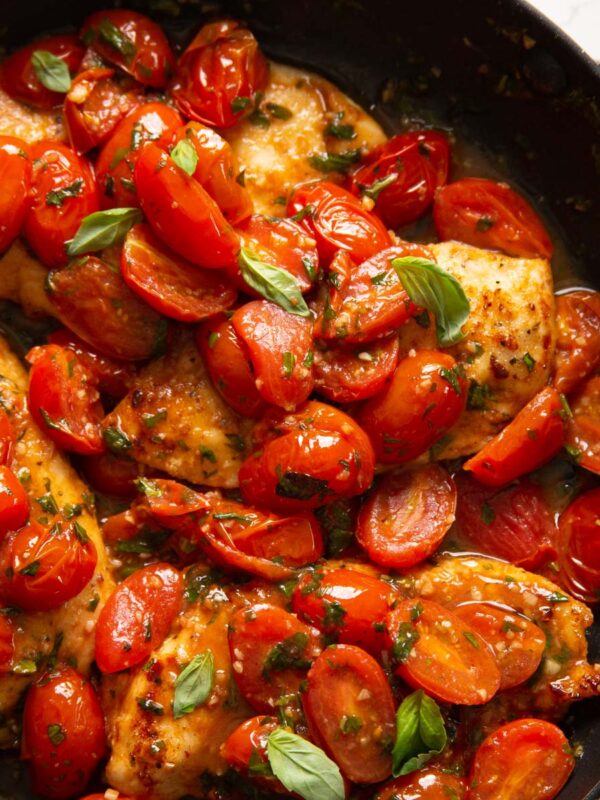 tomato basil chicken in large pan garnished with extra basil