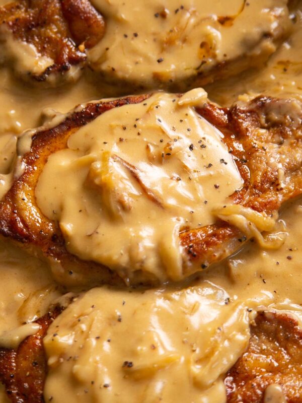 close up shot of smothered pork chops in pan