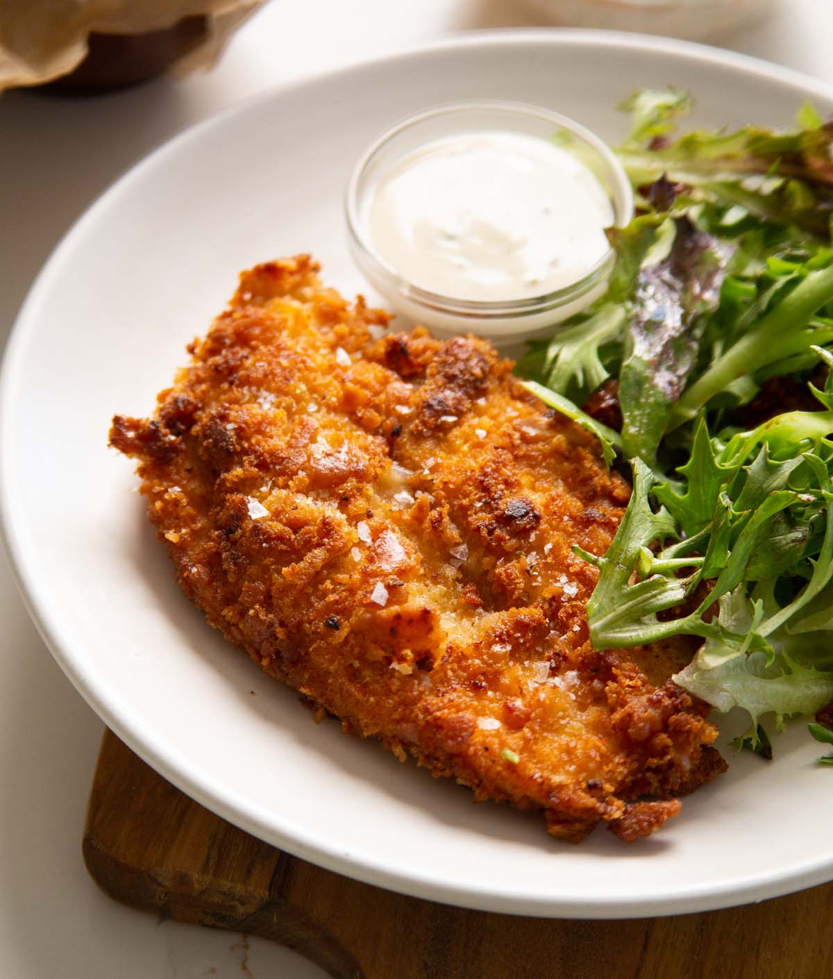 ritz cracker chicken served on small white plate with ranch and side salad