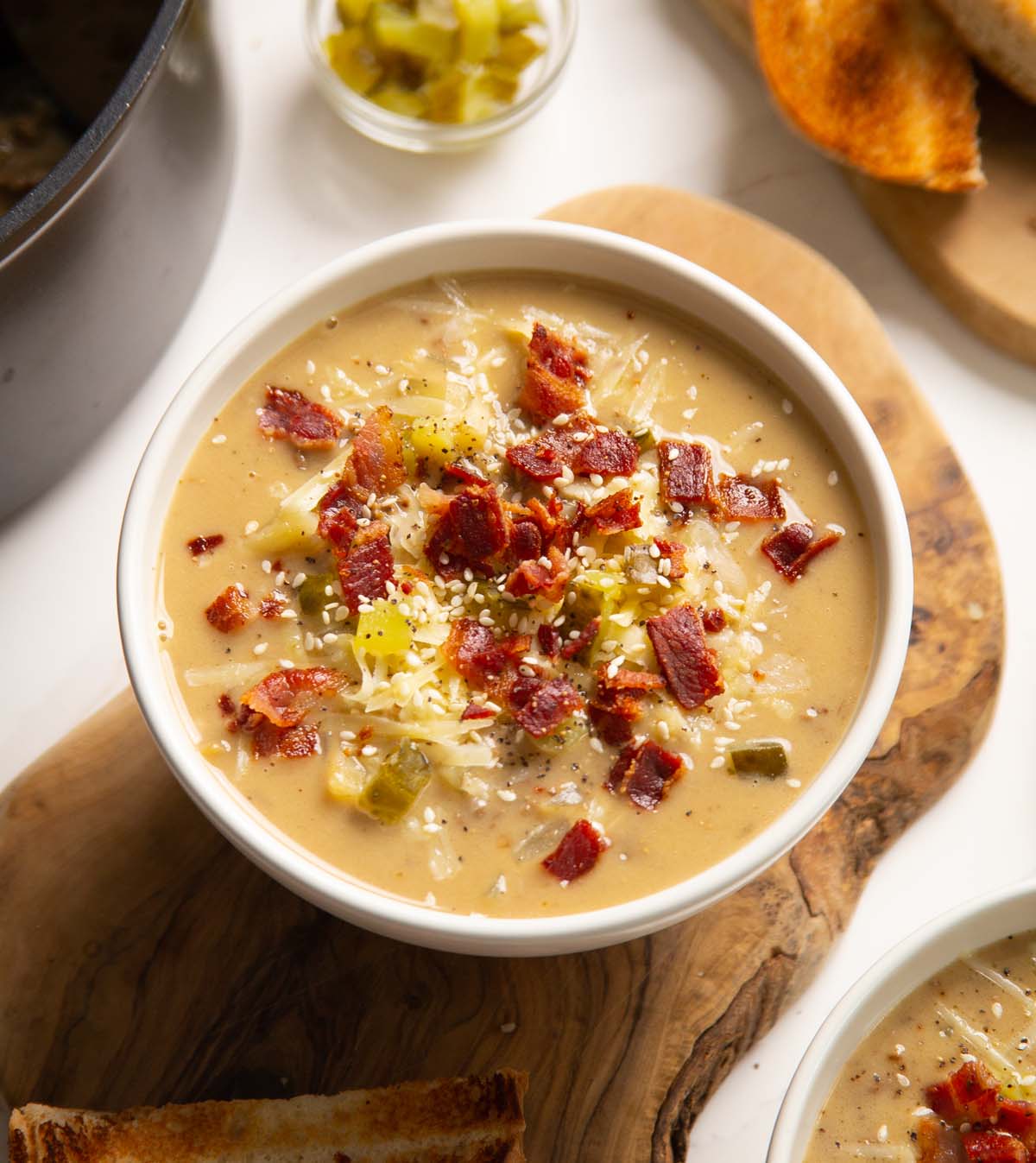 cheeseburger soup in small white bowl on chopping board
