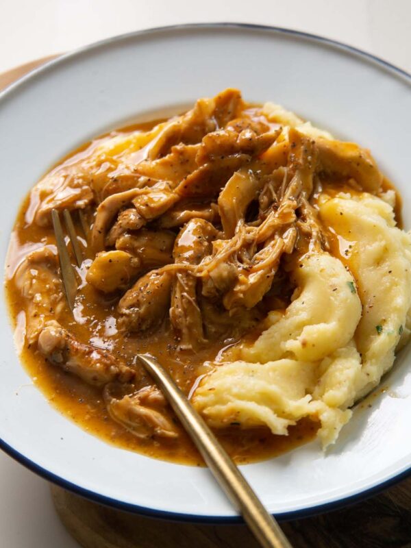 chicken and gravy served in white dish with gold fork