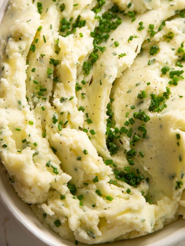 close up shot of sour cream chive mashed potatoes in large white dish
