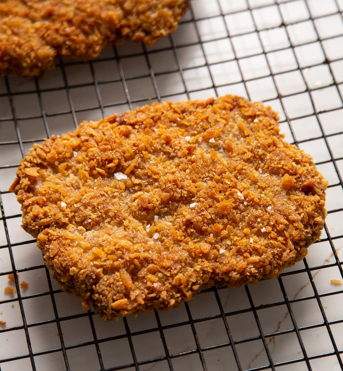 close up shot of sausage schnitzels on wire rack