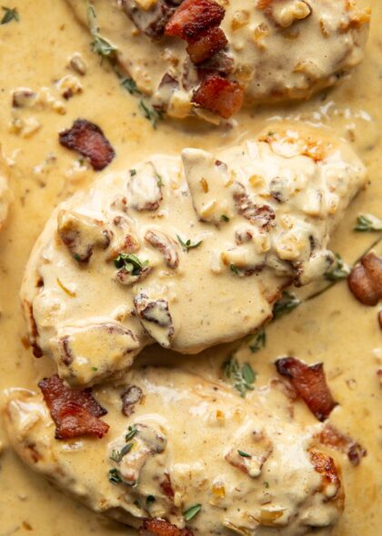 overhead shot of chicken breasts in creamy bacon sauce in skillet